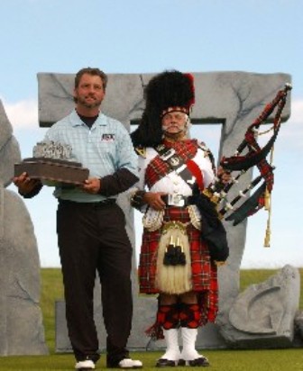 Paul with a Scottish bagpiper at a monument